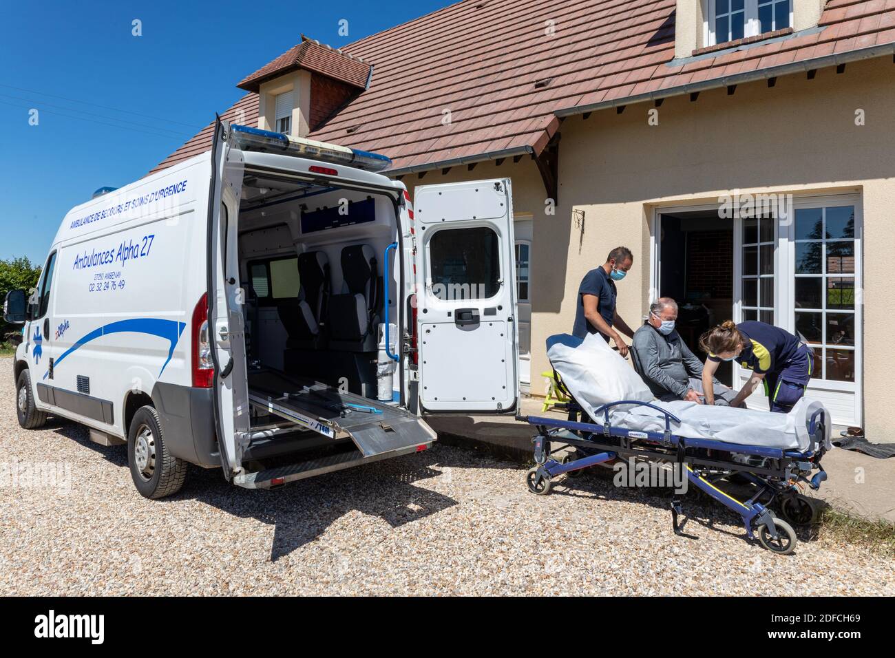 AMBULANZA, ALPHA27, INTERVENTO A CASA DI UNA PERSONA, PORTANDO IL PAZIENTE IN ASSISTENZA, AMBENAY, EURE, NORMANDIA, FRANCIA, EUROPA Foto Stock