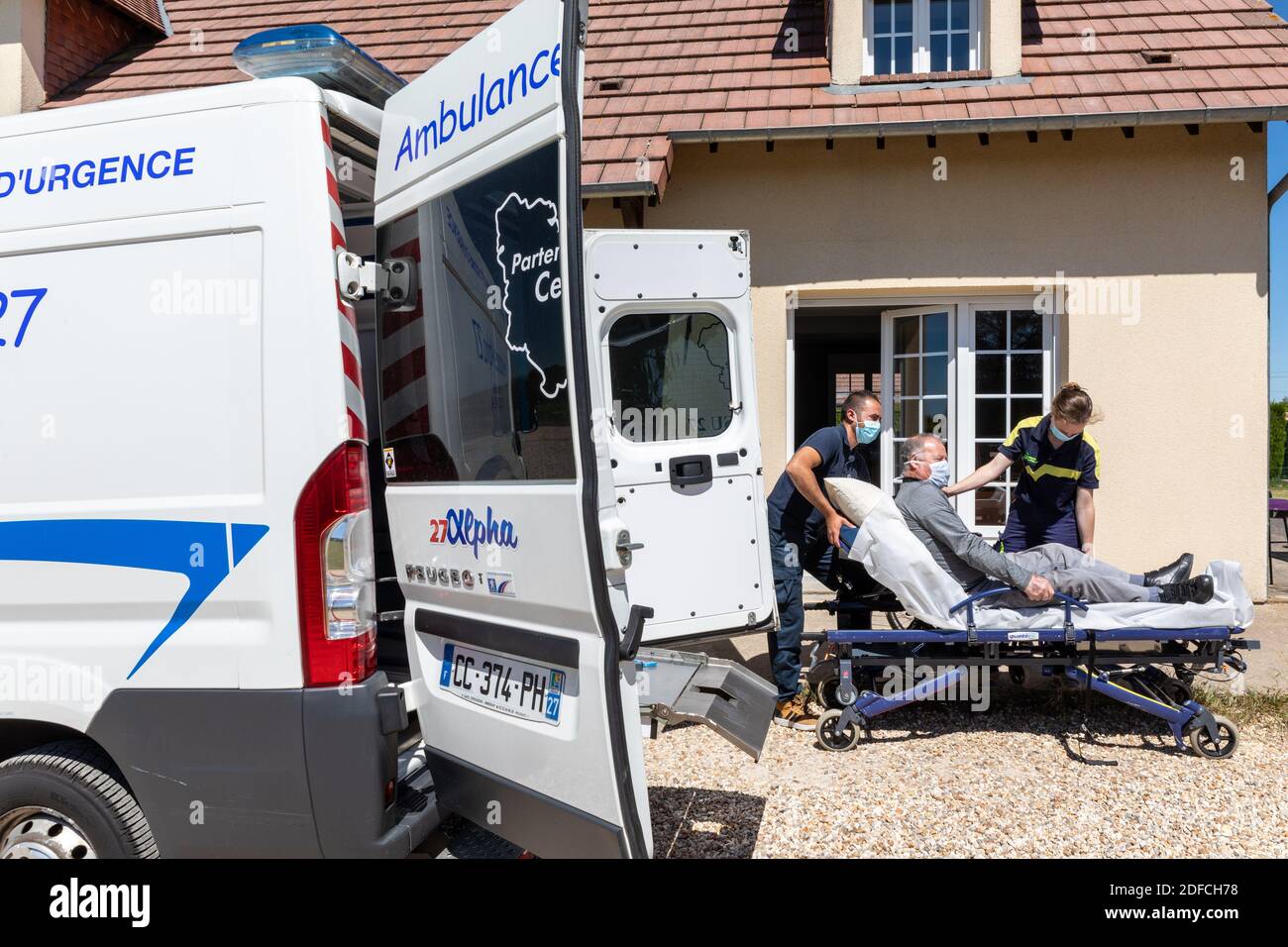 AMBULANZA, ALPHA27, INTERVENTO A CASA DI UNA PERSONA, PORTANDO IL PAZIENTE IN ASSISTENZA, AMBENAY, EURE, NORMANDIA, FRANCIA, EUROPA Foto Stock