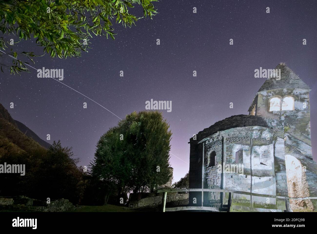Il percorso della Stazione spaziale Internazionale (ISS) nel cielo notturno sull'abbazia di San Pietro in Vallate, Valtellina, Lombardia, Italia Foto Stock