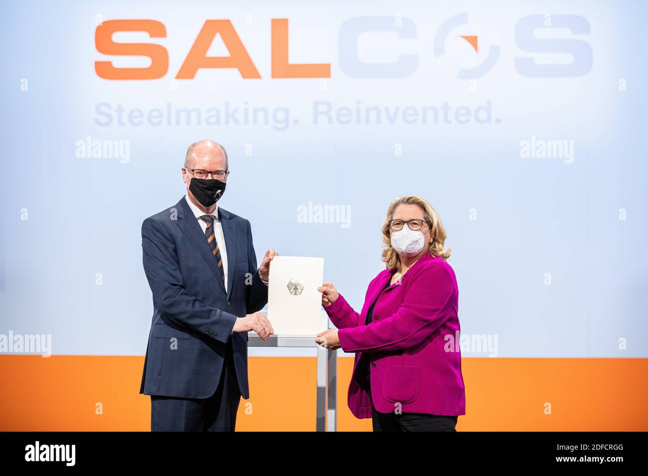 Salzgitter, Germania. 04 dicembre 2020. Svenja Schulze (SPD), ministro federale dell'ambiente, presenta Heinz Jörg Fuhrmann, presidente del comitato esecutivo della Salzgitter AG, con avviso di approvazione per la costruzione del primo impianto di riduzione diretta (impianto DRI) Per la produzione di acciaio praticamente privo di CO2 che può essere azionato in modo flessibile con idrogeno e gas naturale. Credit: Moritz Frankenberg/dpa/Alamy Live News Foto Stock