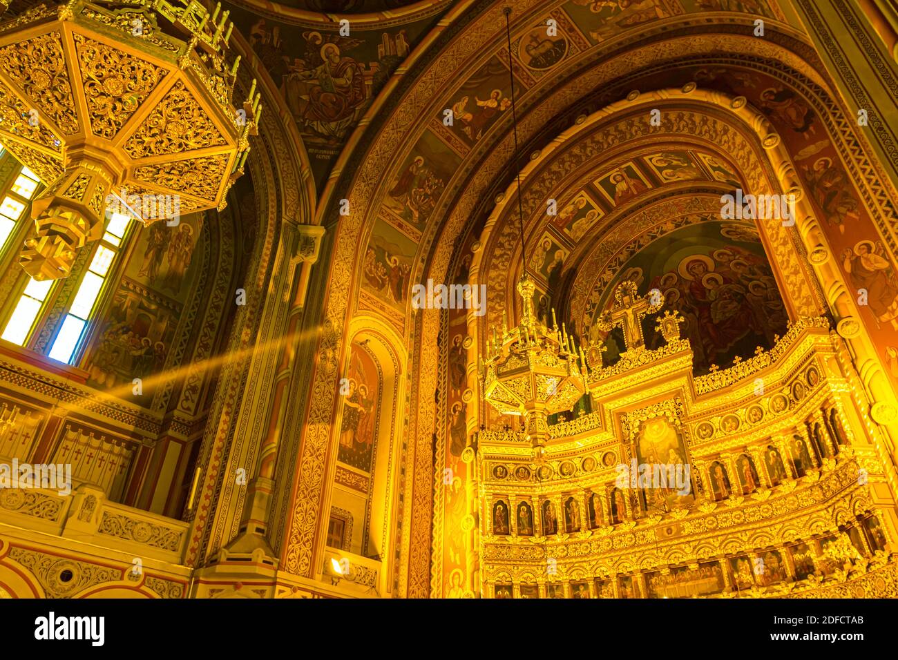 Vista dal basso su lampadari dorati appesi sul soffitto, all'interno della vecchia cattedrale ortodossa di Timisoara, Romania. Foto Stock