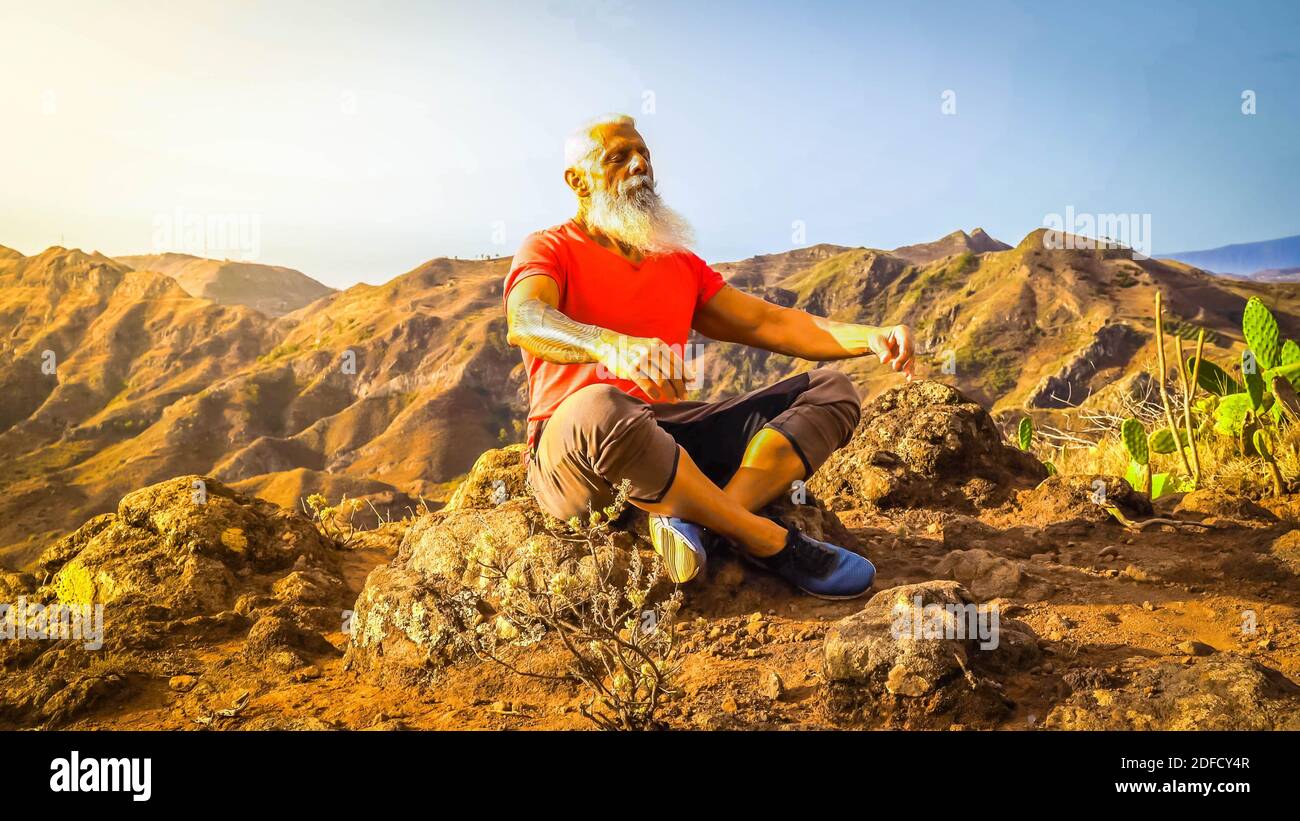 Uomo anziano saluto tramonto Foto Stock