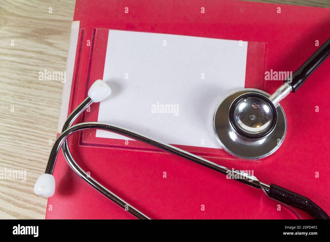 Lima rossa e stetoscopio nero su sfondo di legno Foto Stock