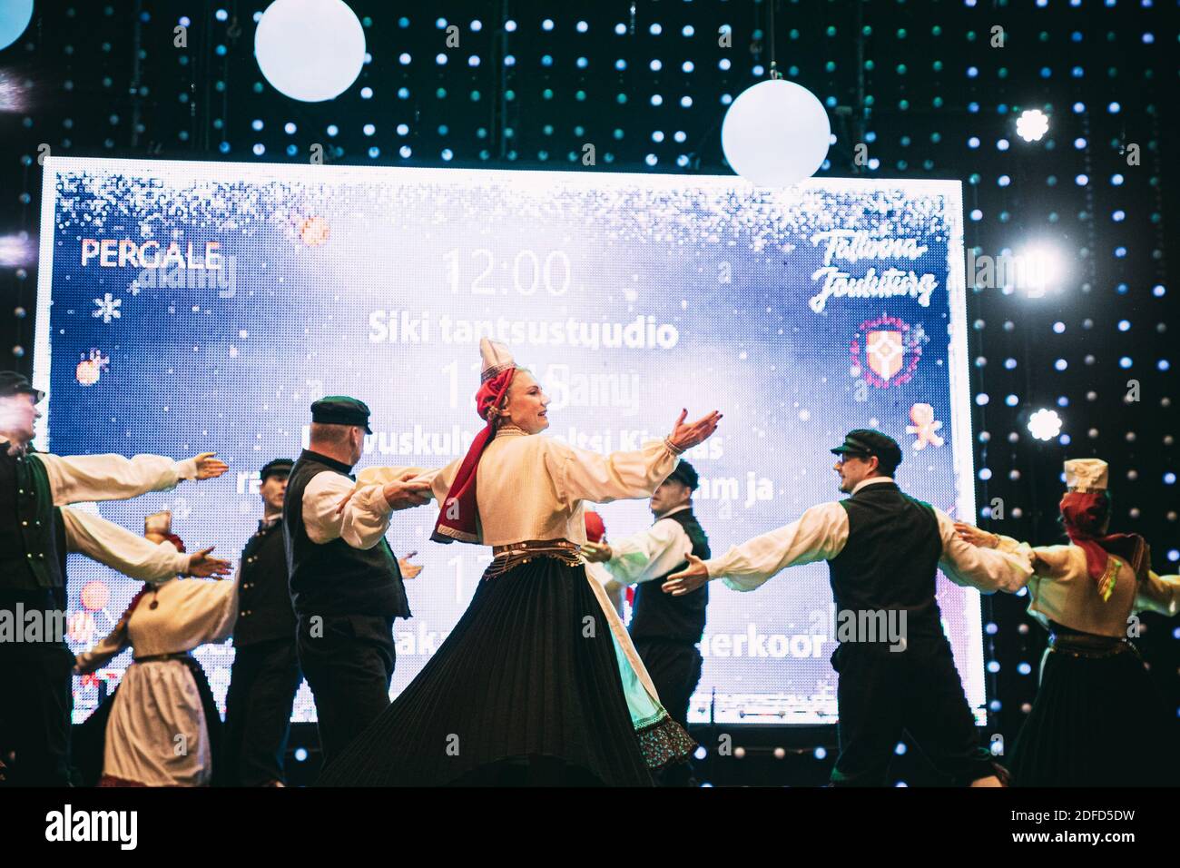 Tallinn, Estonia. Ballerini in tute nazionali che eseguono balli folcloristici durante la tradizionale celebrazione delle feste di Natale. Foto Stock