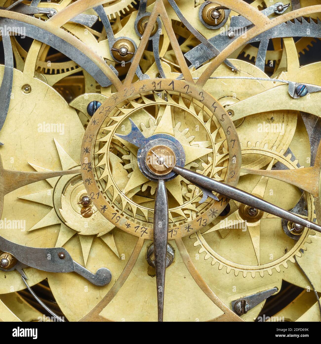 Innerworks di un antico orologio con ruote dentate e ora e la mano del minuto Foto Stock