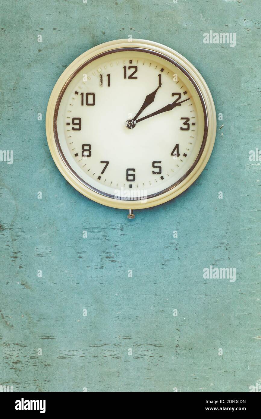 Orologio elettrico in plastica vintage della metà del ventesimo secolo su un blu parete resistente alle intemperie Foto Stock