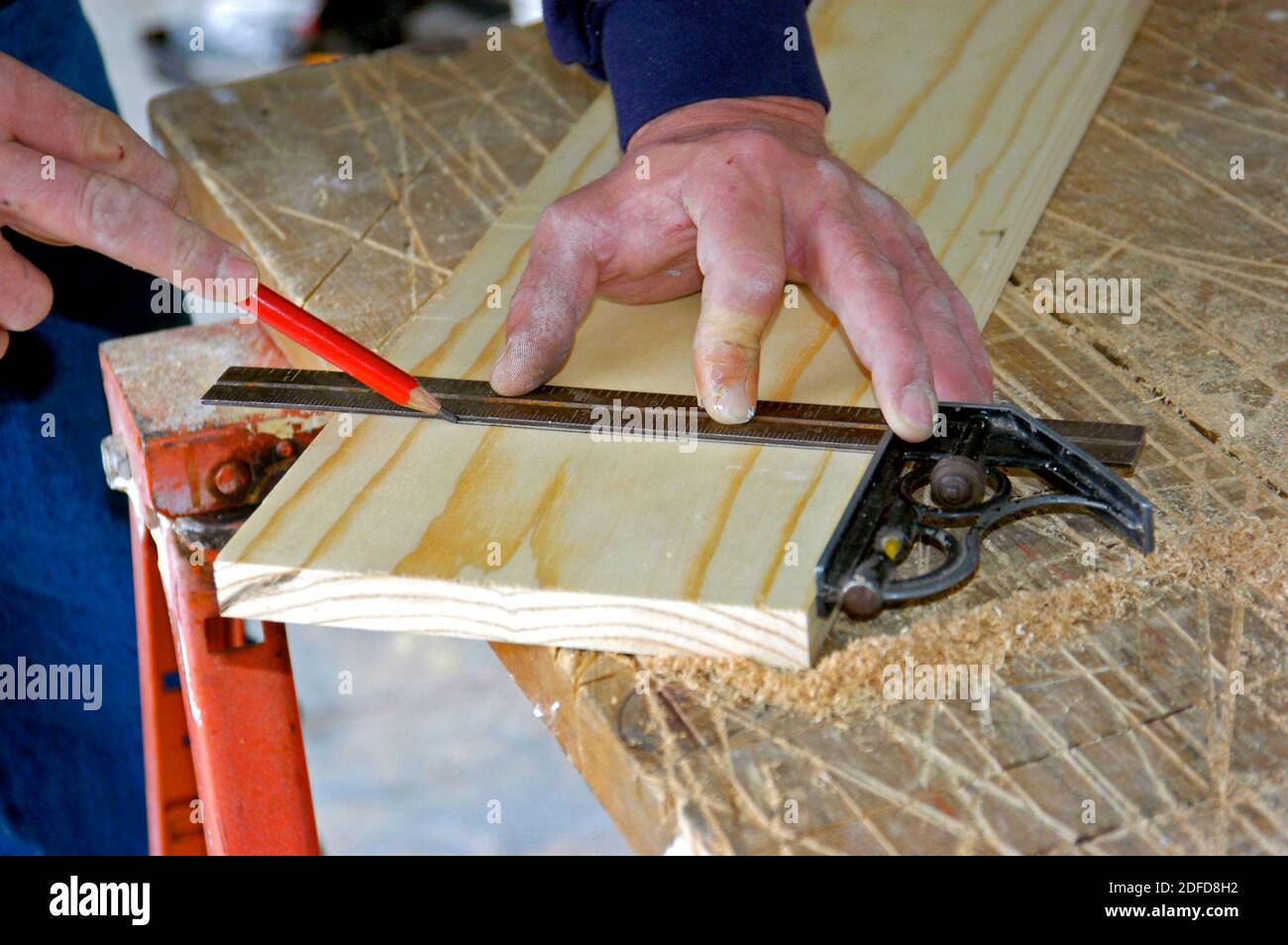Falegname con strumento quadrato manuale per effettuare una misurazione precisa Foto Stock