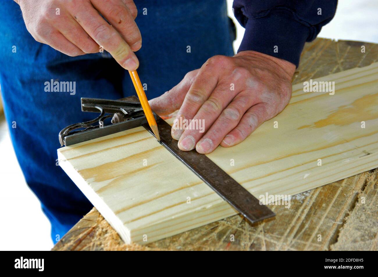 Falegname con strumento quadrato manuale per effettuare una misurazione precisa Foto Stock