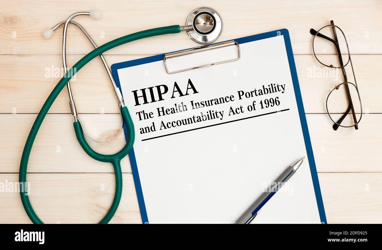 Scrivania da ufficio, notebook, occhiali, penna e documenti con HIPAA The Health Insurance Portability and Accountability Act del 1996 sul titolo Foto Stock