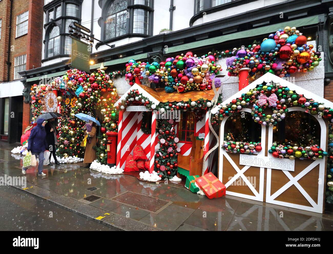 Londra, Regno Unito. 03 dic 2020. La gente passa accanto al Ivy Chelsea Garden. Il Ivy Chelsea Garden si è trasformato in Grotta di Santa per Natale. Il ristorante alla moda lungo la King's Road ha avuto un restyling festivo con l'installazione che include la mailroom di Babbo Natale, le scuderie di renna, l'albero di Natale, le decorazioni e la slitta di Babbo Natale. Credit: SOPA Images Limited/Alamy Live News Foto Stock