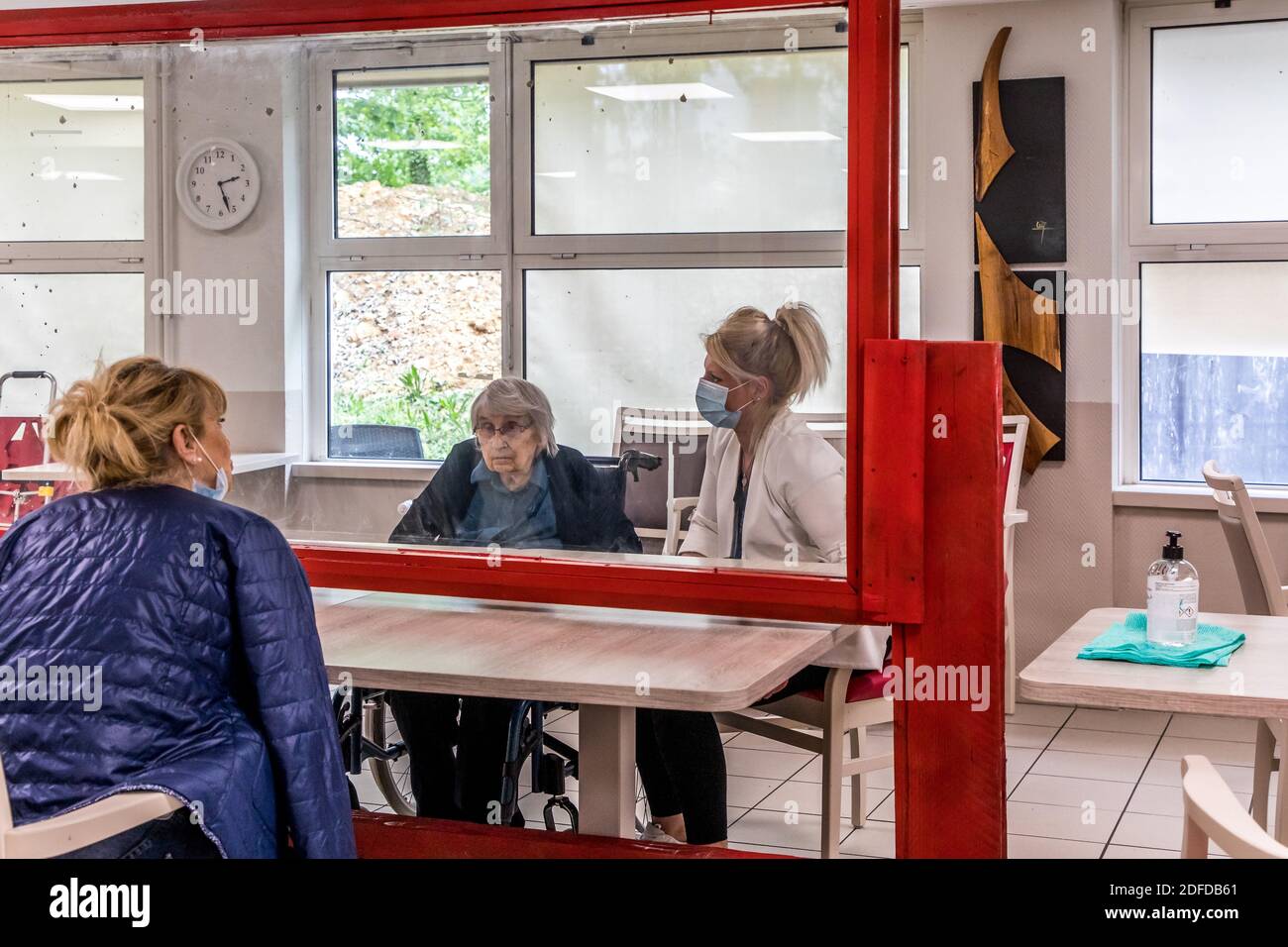 FAMIGLIE CHE VISITANO I LORO GENITORI IN UNA CASA DI RIPOSO IN CONFORMITÀ CON LE NORME SULLA DISTANZA SOCIALE DURANTE LA PANDEMIA COVID-19, EHPAD DI MALNOUE, EMERAINVILLE (77), SEINE ET MARNE, FRANCIA, EUROPA Foto Stock