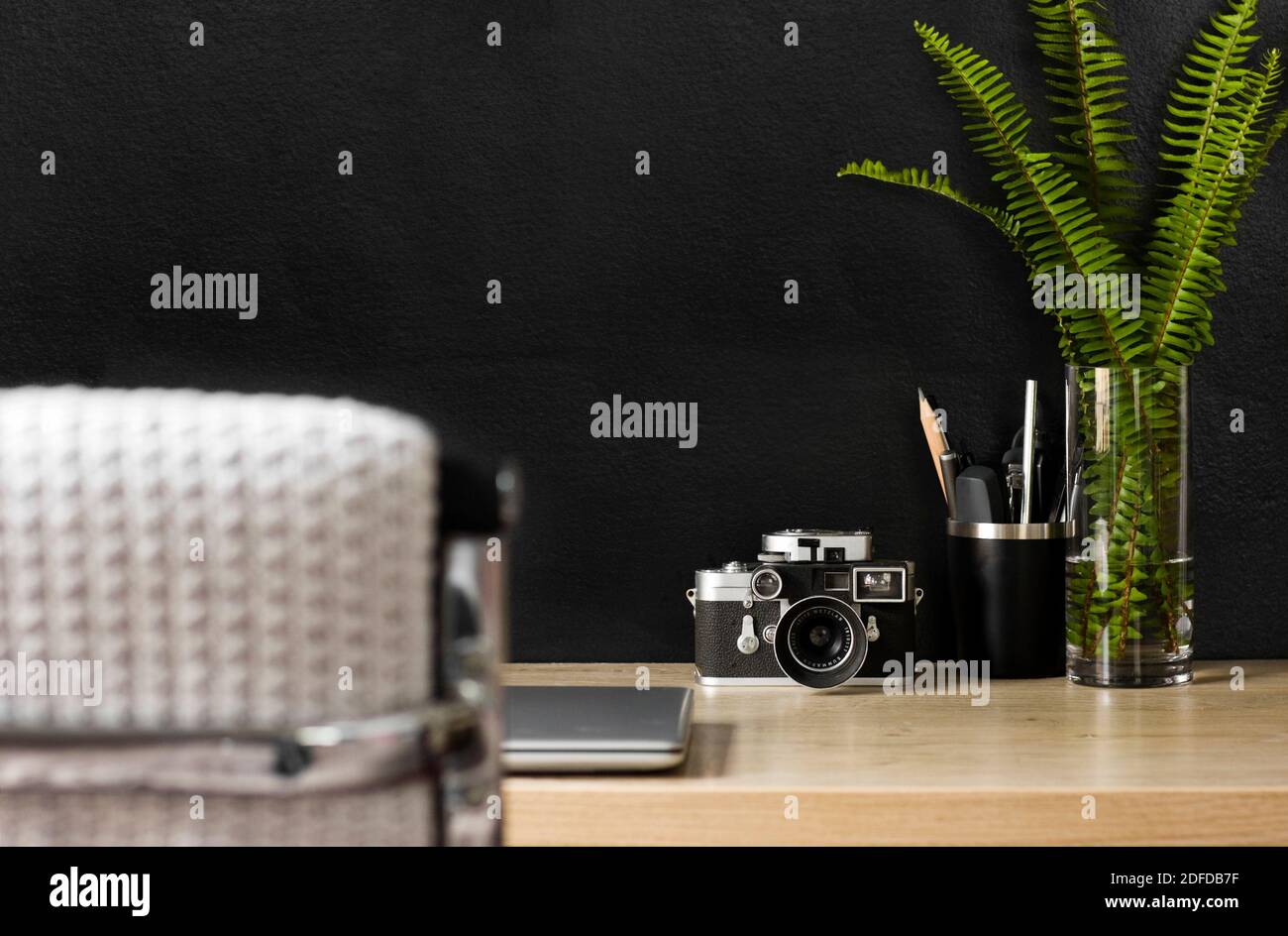 Uno spazio organizzato per l'ufficio domestico con una fotocamera vintage. Il decor color crema, nero e argento creano un'atmosfera rilassata per lavorare in modo produttivo da casa. Foto Stock