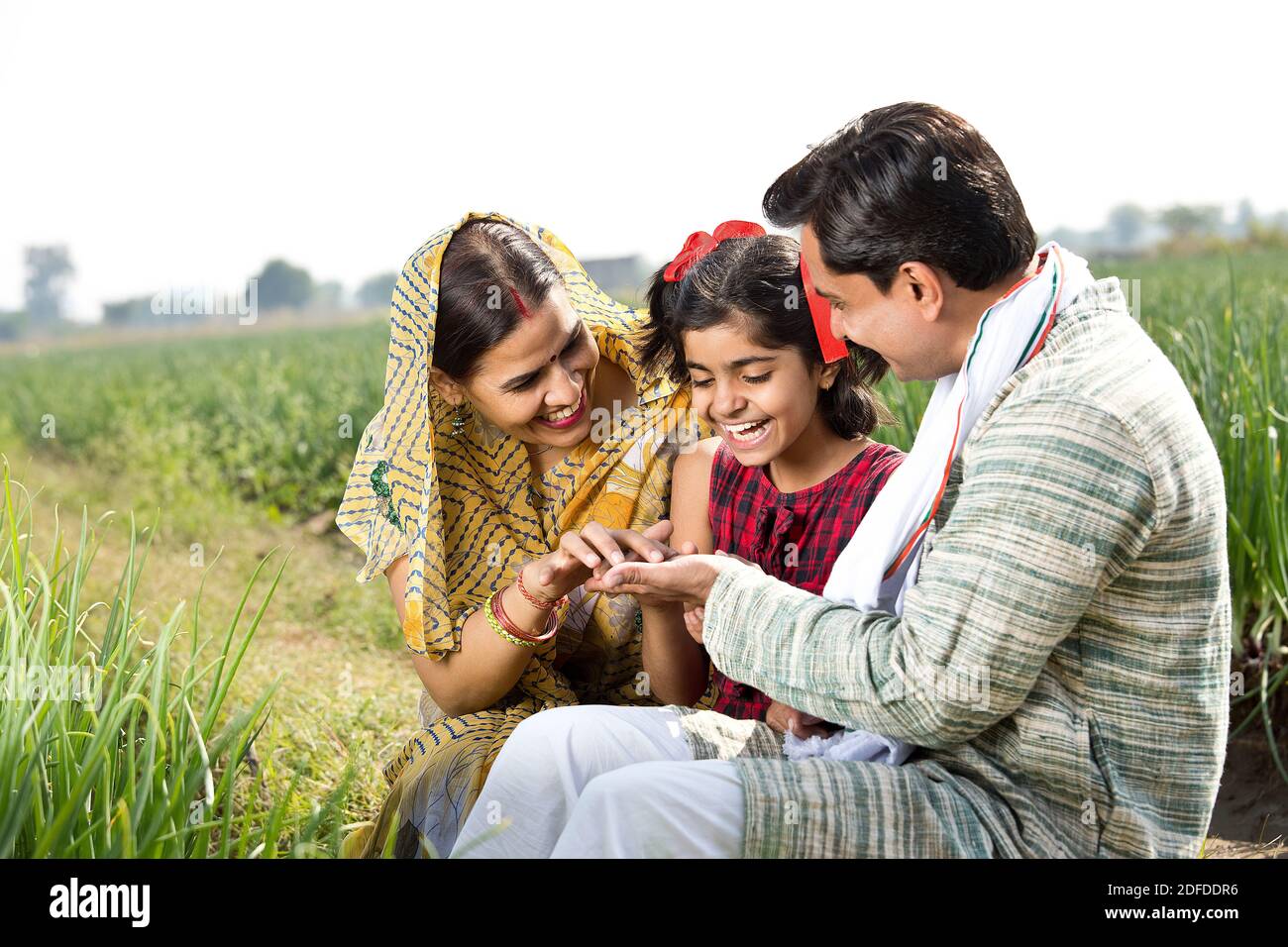 Felice famiglia indiana di contadino in campo agricolo Foto Stock