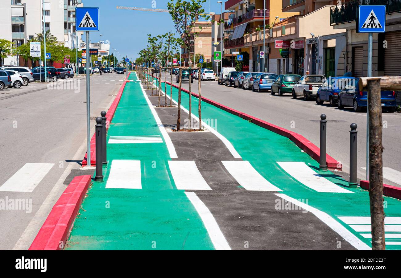 Modugno, Italia - 17 novembre 2019: Cartelli dipinti su asfalto per piste ciclabili dedicate. Una pista ciclabile separata in città, ciclisti sulla pista ciclabile Foto Stock