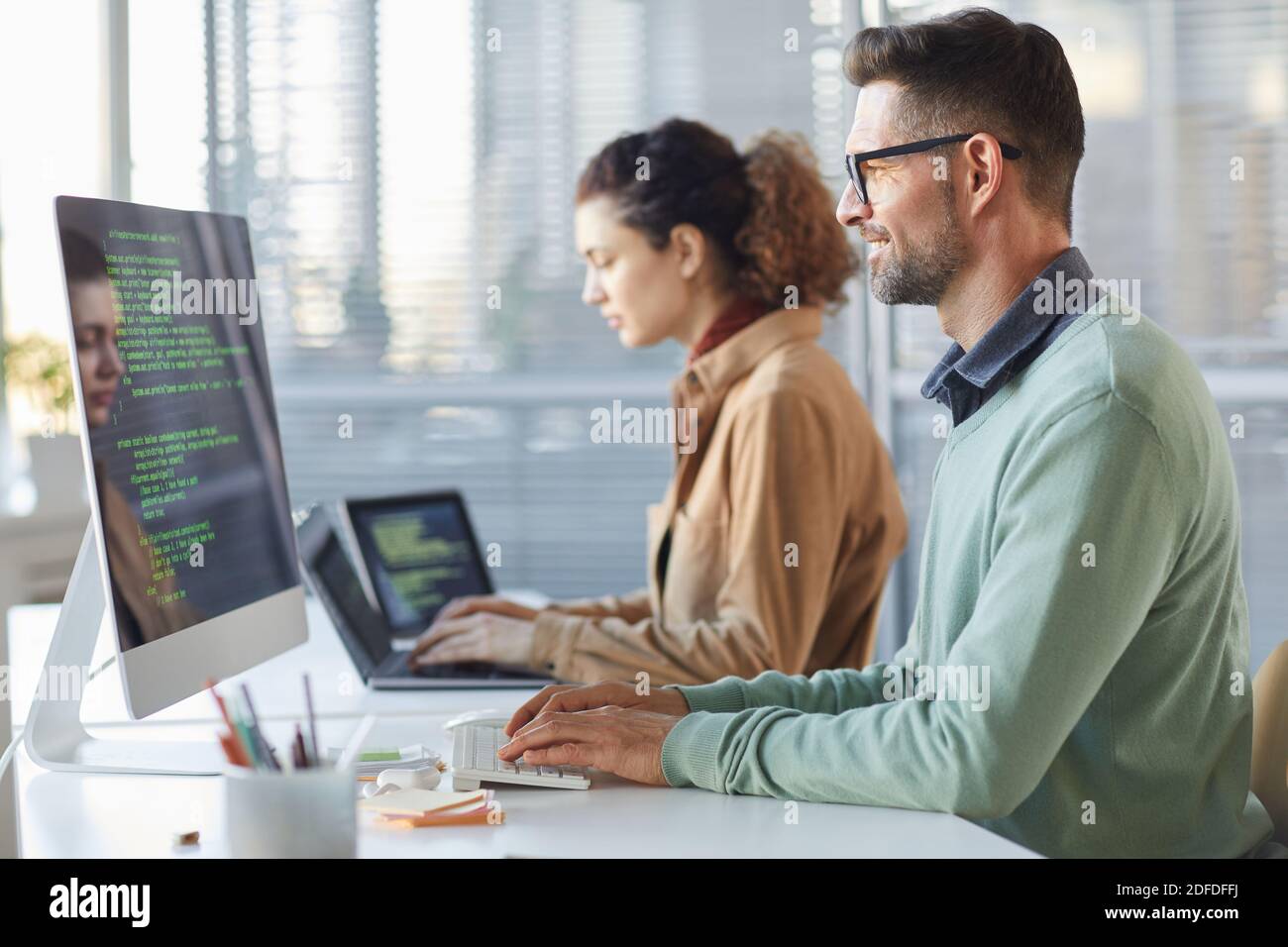 Programmatori che scrivono il codice dati lavorando sul progetto nello sviluppo del software azienda Foto Stock