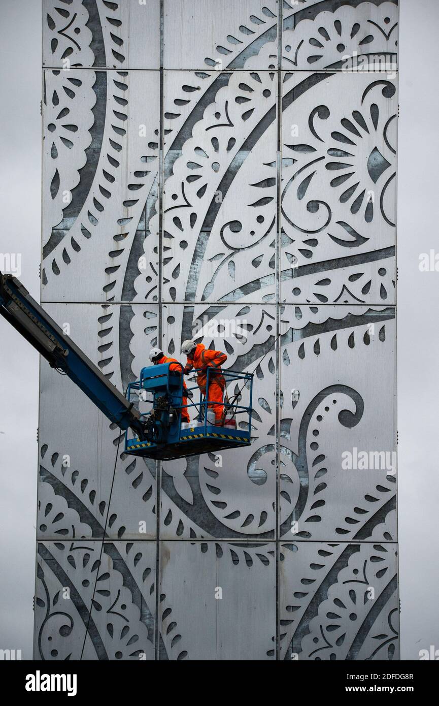 Glasgow, Scozia, Regno Unito. 4 Dicembre 2020. Nella foto: Operai in DPI alto viz arancione visto su un picker ciliegia che fa il tocco finale alla Torre M8 - una struttura in acciaio inossidabile alto 131ft adornata con la forma paisley a goccia, che mostra una gigantesca scheda pubblicitaria elettronica sopra il Viadotto White Cart, che mostrerà gli annunci pubblicitari al traffico in direzione nord. La struttura costò più di un milione di sterline, essendo finanziata da Wildstone, la più grande azienda pubblicitaria all'aperto del Regno Unito. Credit: Colin Fisher/Alamy Live News Foto Stock