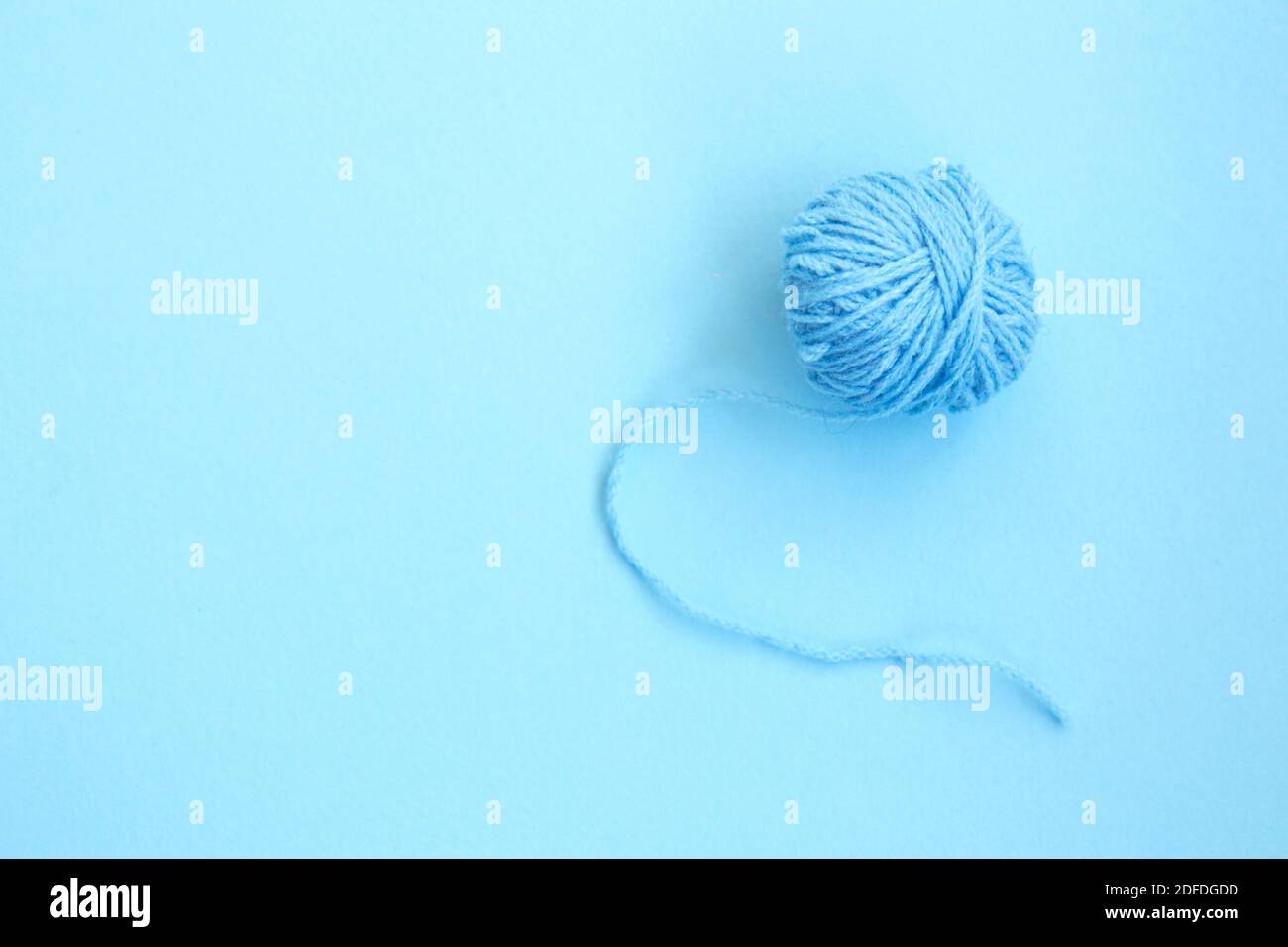 Sfera blu di filo di lana su sfondo blu con copia spazio Foto Stock