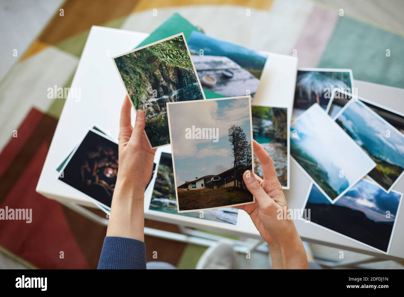 Primo piano di donna che tiene le foto in mano ricordandola momenti migliori Foto Stock