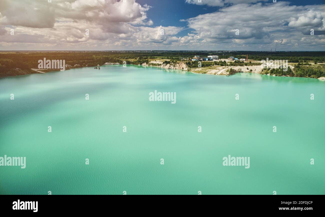 Grande lago verde in cava aerea sopra la vista dall'alto giorno di sole luminoso Foto Stock