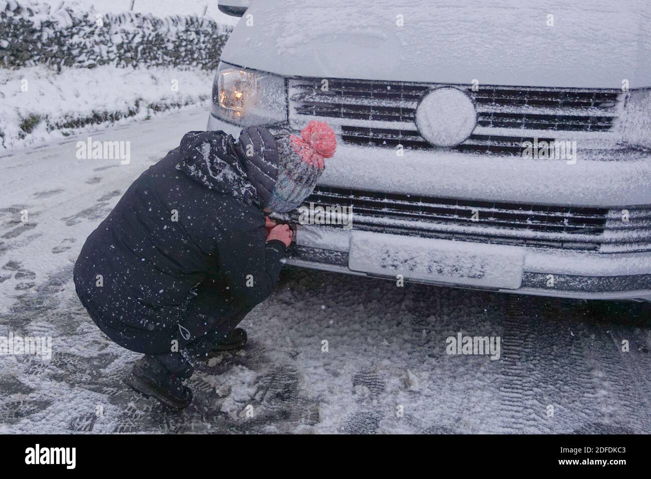 Mamor Tor, Regno Unito. 4 Dicembre 2020. Una donna cerca di riparare la sua auto vicino a Mamor Tor dopo una nevicata la scorsa notte. Credit: Joannis Alexopoulos/Alamy Live News Foto Stock