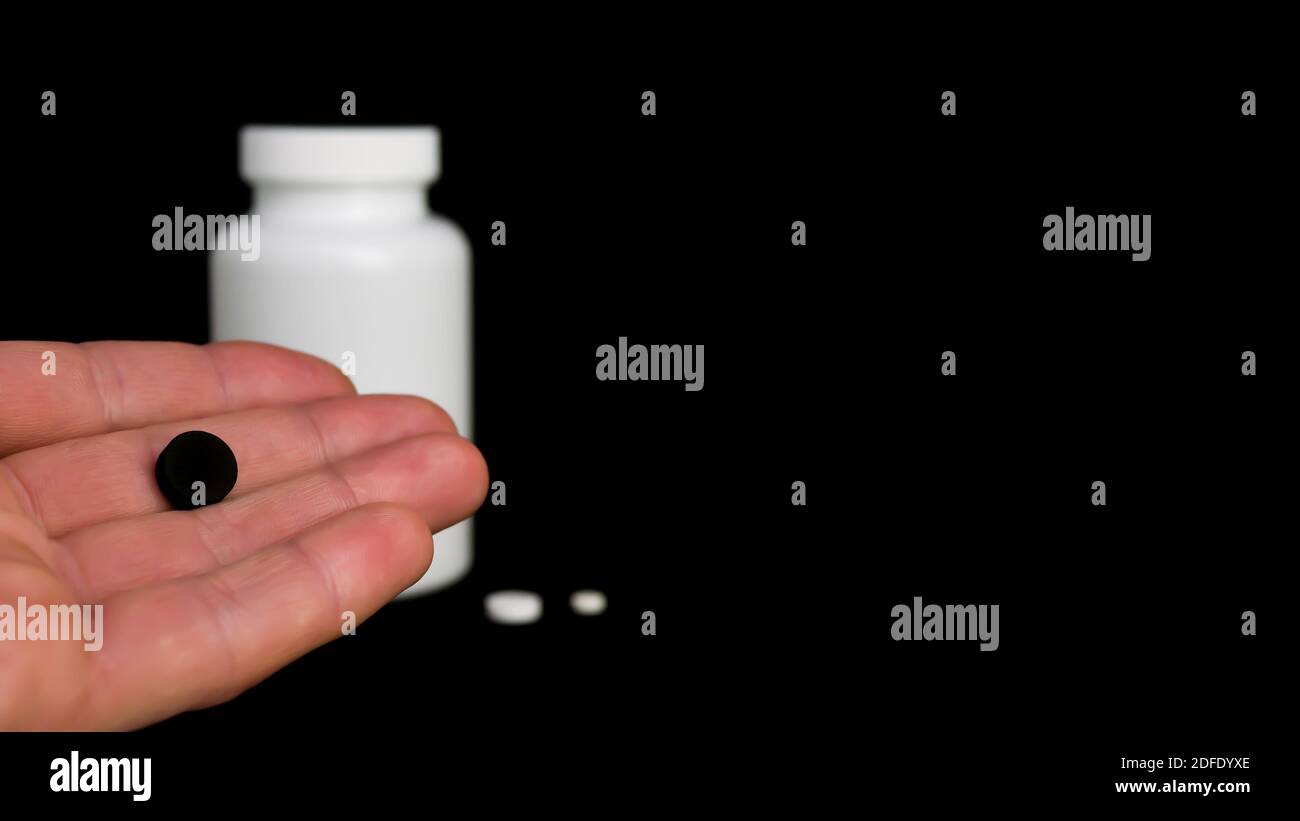 Tavoletta nera in mano di un uomo. Varie sostanze narcotiche. Spazio di copia per il testo. Foto a stock per il design Foto Stock