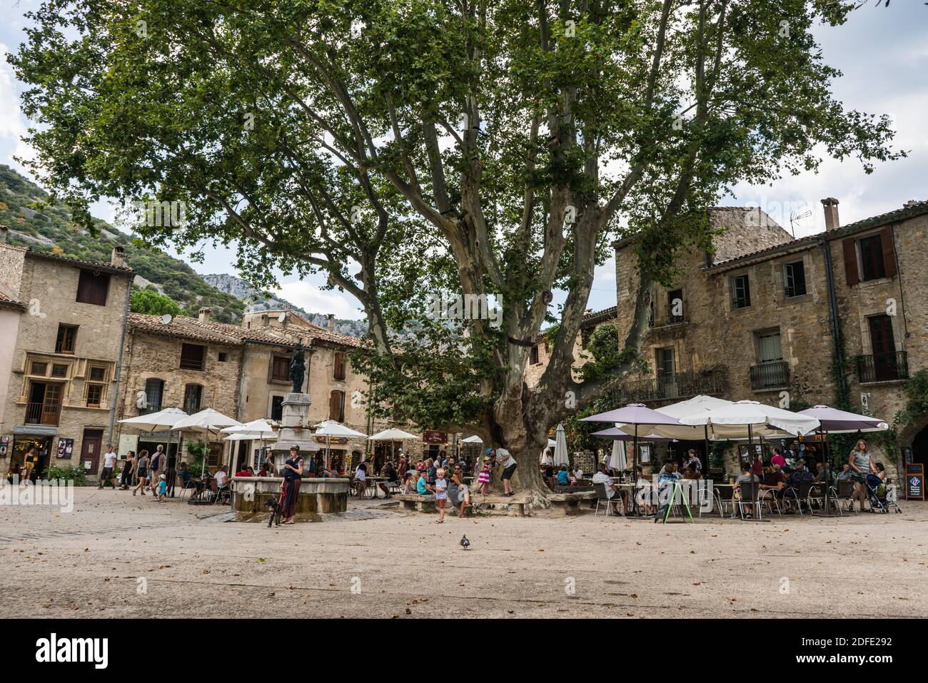 Gente locale e turisti nella piazza principale del Saint-Guilhem-le-Désert, Languedoc-Roussillon, Francia, Europa. Foto Stock