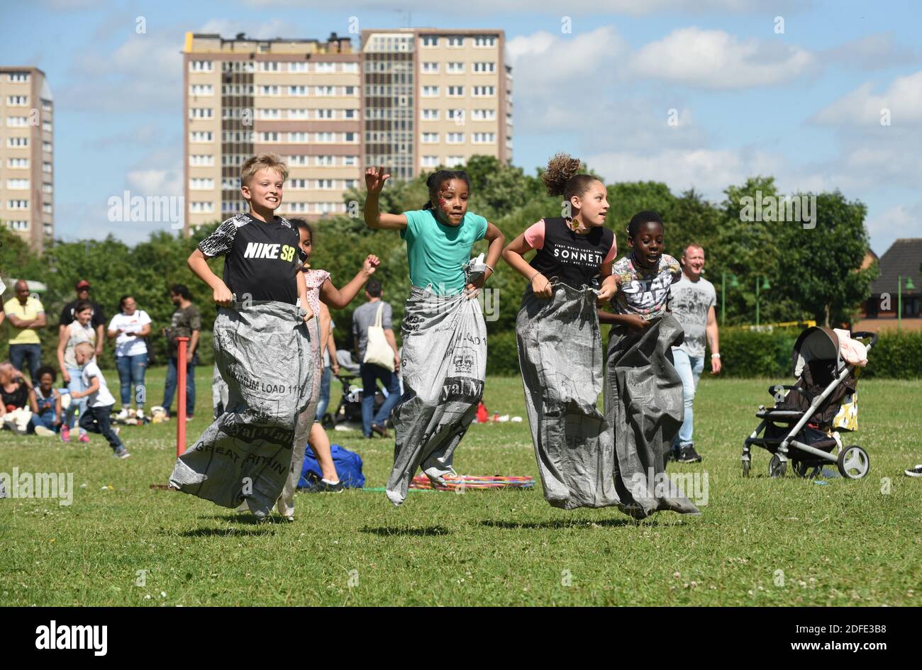 Bambini che giocano la corsa del sacco nel parco di Nechells, Birmingham Foto Stock