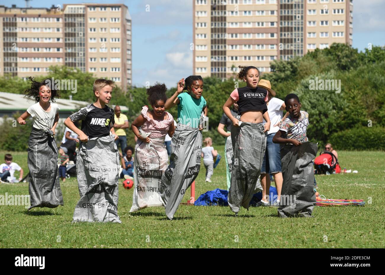 Bambini che giocano la corsa del sacco nel parco vicino a Nechells, Birmingham Foto Stock