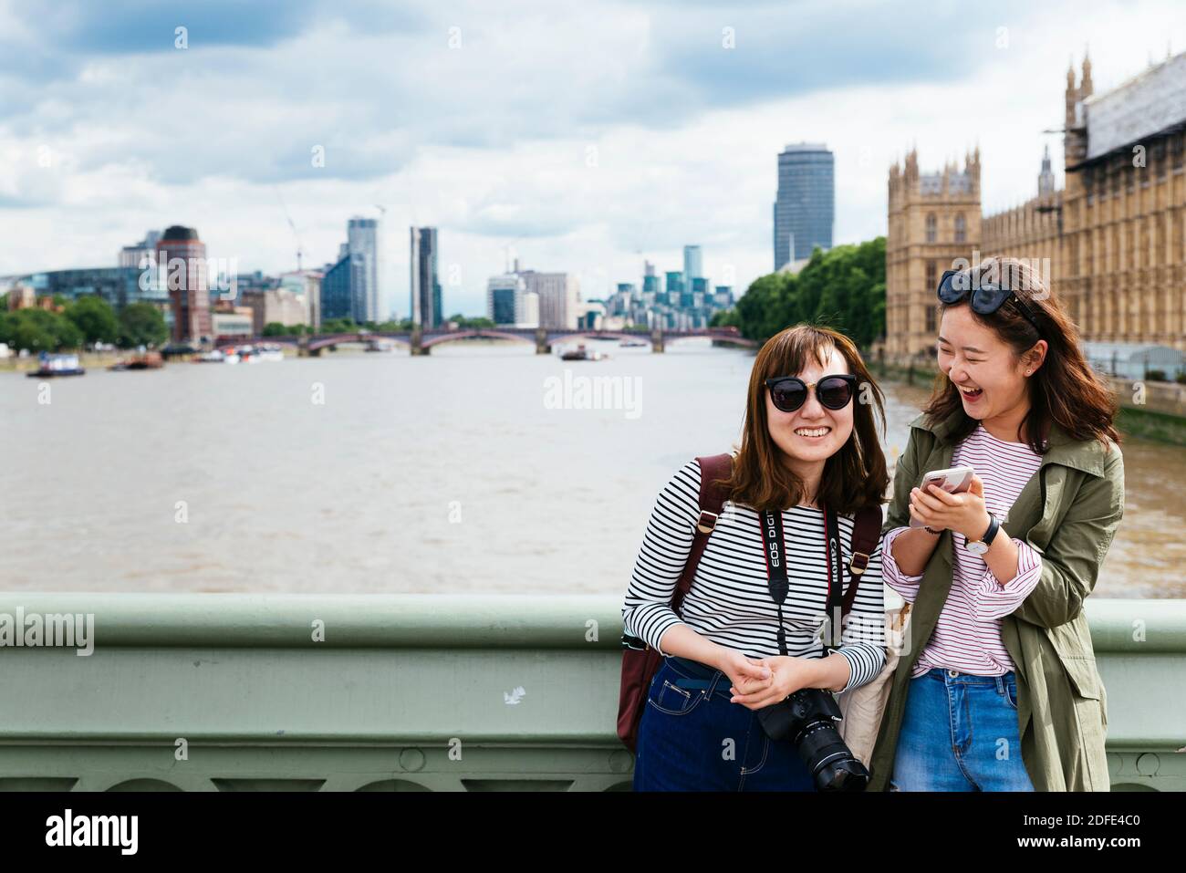 Due giovani donne asiatiche sul ponte di Westminster. Londra, Inghilterra, Regno Unito, Europa Foto Stock