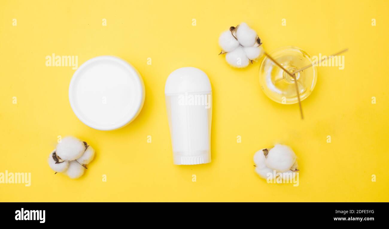vasetti bianchi per prodotti per l'igiene personale su sfondo giallo, spazio per la copia, vista dall'alto Foto Stock