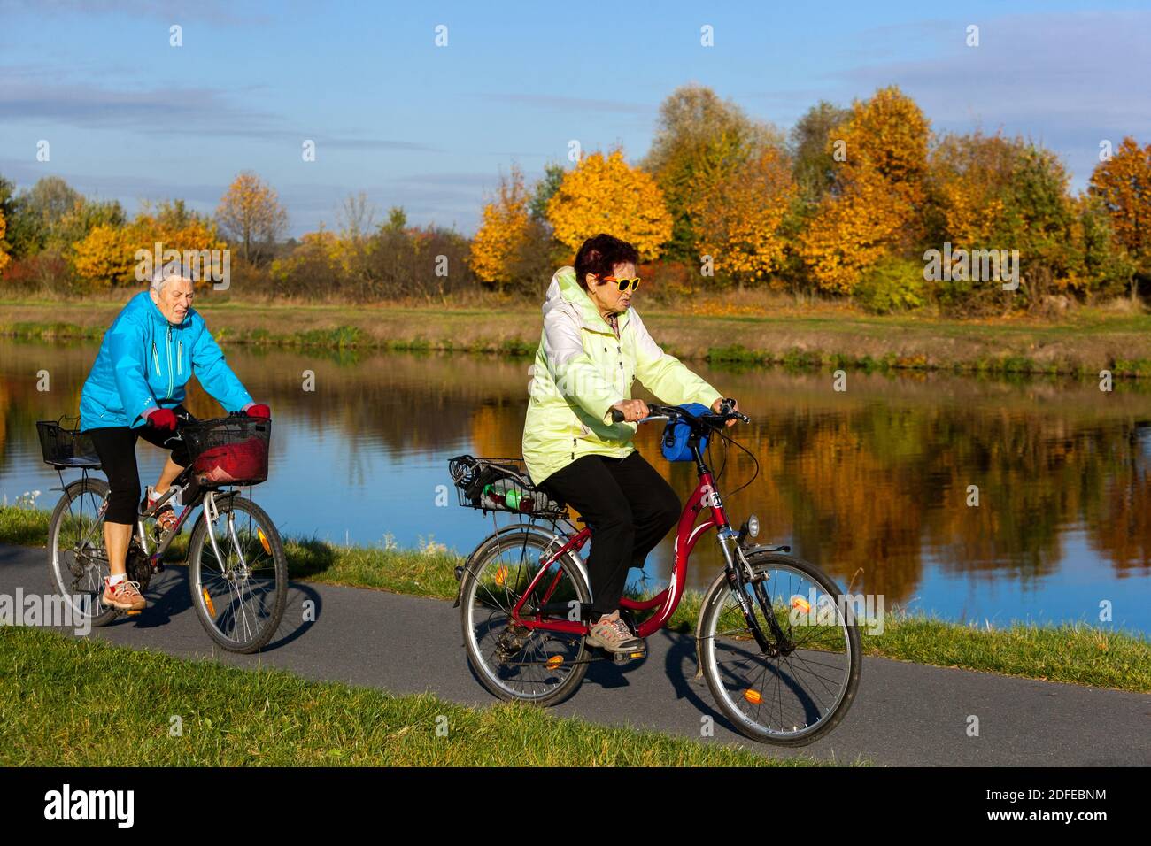 Due donne anziane in bicicletta lungo il sentiero del fiume Elba in autunno Foto Stock