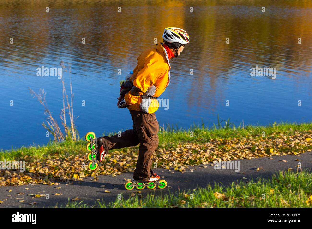 Uomo anziano pattinaggio a rotelle lungo il fiume stile di vita sano persona anziana Foto Stock