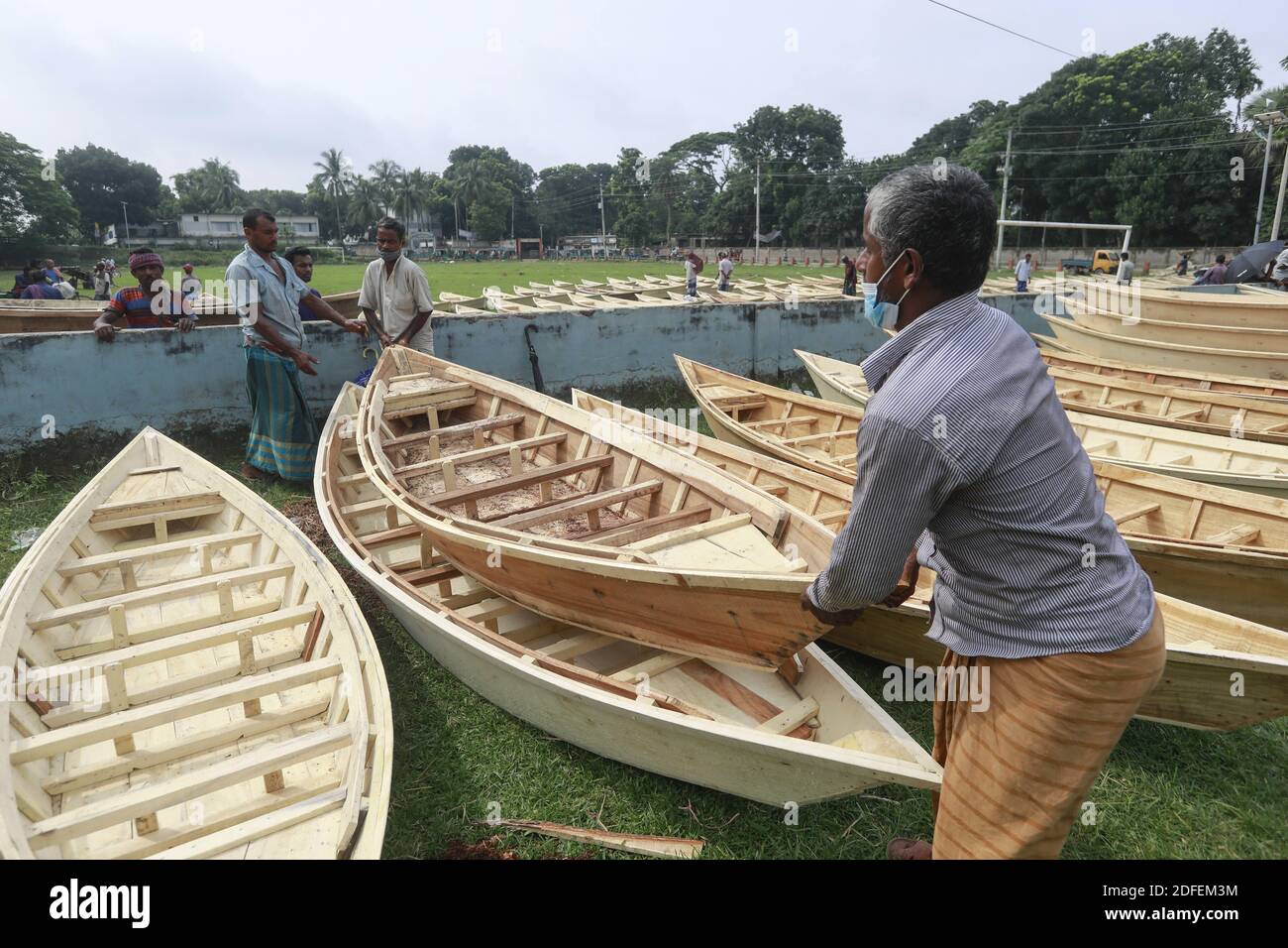 I commercianti del Bangladesh scaricano la loro barca da un carrello ad un mercato della barca a Ghior, Manikgan, Bangladesh, il 08 luglio 2020. La domanda di vari tipi di imbarcazioni di piccole dimensioni è aumentata qui con l'aumento del livello dell'acqua nei diversi fiumi e le successive inondazioni. La domanda di Dingi e Khosa Nauka (piccola imbarcazione) è aumentata per la circolazione regolare delle persone nelle aree soggette a inondazioni. Foto di Suvra Kanti Das/ABACAPRESS.COM Foto Stock