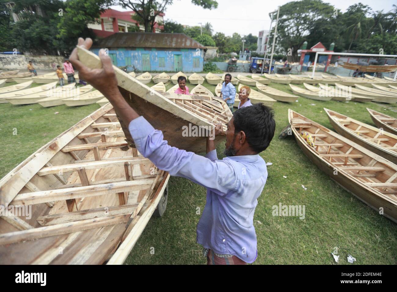 I commercianti del Bangladesh scaricano la loro barca da un carrello ad un mercato della barca a Ghior, Manikgan, Bangladesh, il 08 luglio 2020. La domanda di vari tipi di imbarcazioni di piccole dimensioni è aumentata qui con l'aumento del livello dell'acqua nei diversi fiumi e le successive inondazioni. La domanda di Dingi e Khosa Nauka (piccola imbarcazione) è aumentata per la circolazione regolare delle persone nelle aree soggette a inondazioni. Foto di Suvra Kanti Das/ABACAPRESS.COM Foto Stock