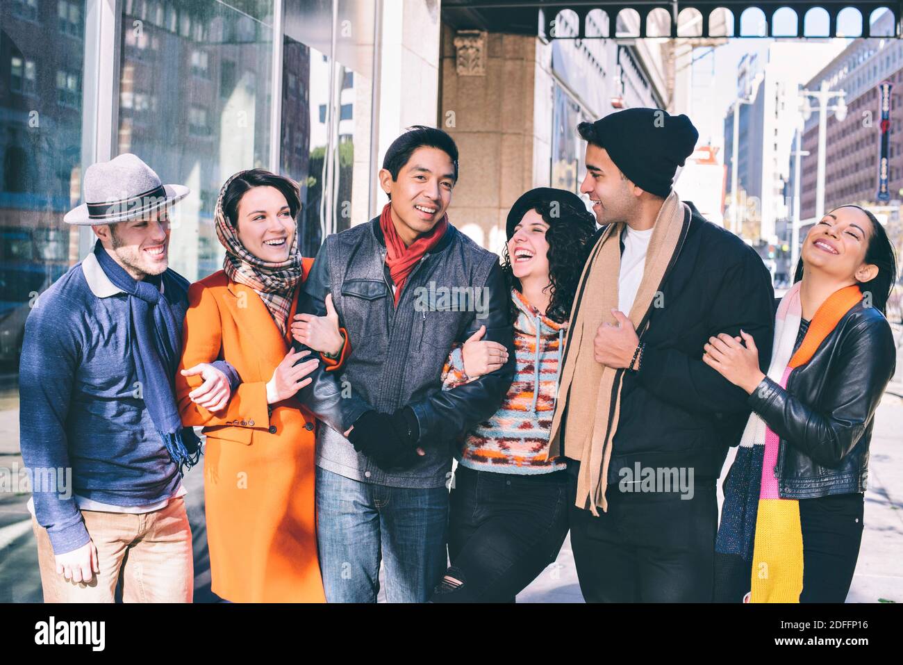 Sei amici millenari camminano in braccio nella loro città Durante il tempo freddo - Vacanze - concetto buoni tempi Foto Stock