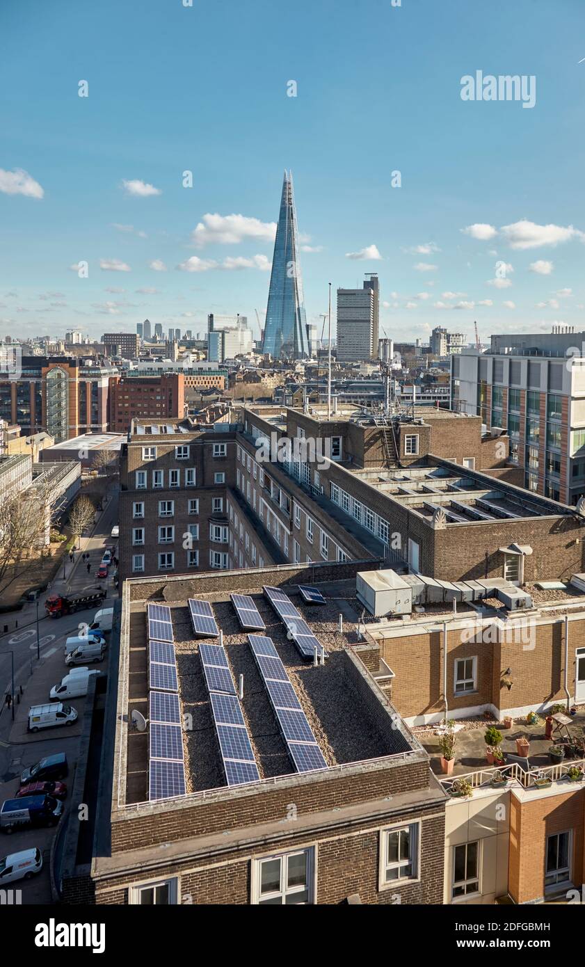 Pannelli solari sul tetto di LSE Bankside House con la Shard in lontananza. Londra, Regno Unito Foto Stock