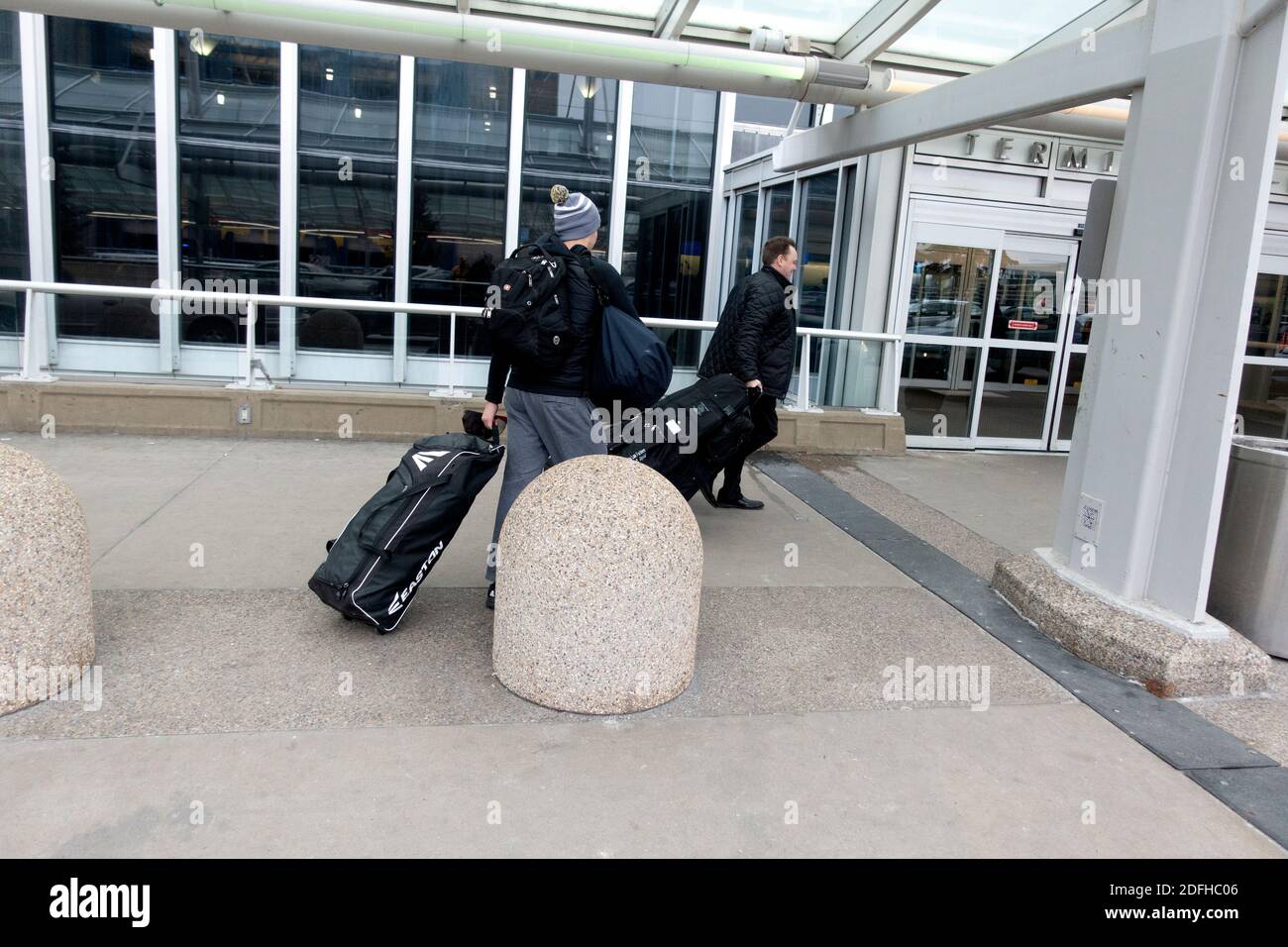 Padre e figlio all'aeroporto internazionale di Minneapolis-Saint Paul che si dirigono verso il loro aereo con i bagagli. Minneapolis, Minnesota, Stati Uniti Foto Stock