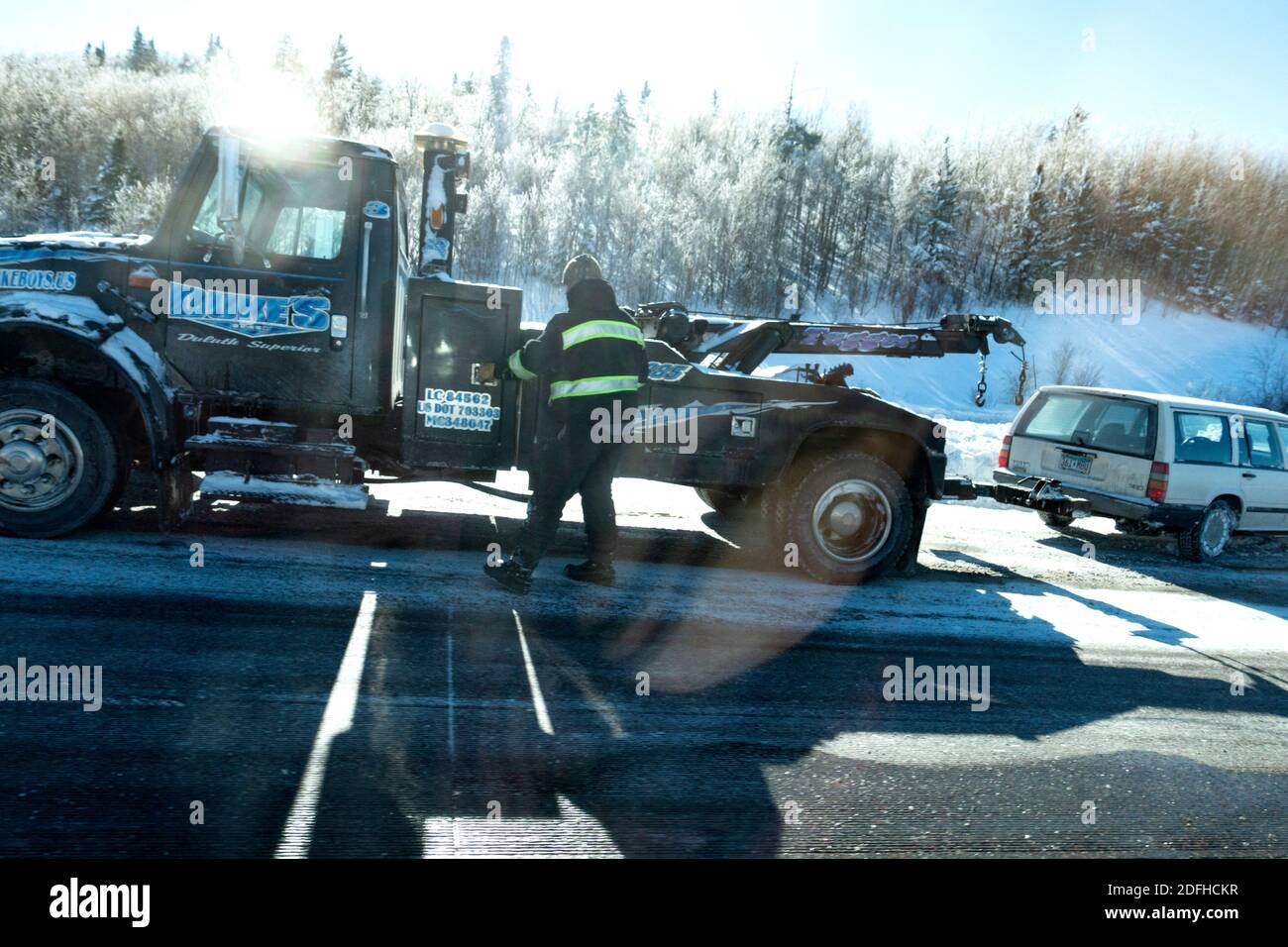 L'autista del camion trainante estrae un'auto in direzione della neve che era scivolata fuori strada vicino a Brule WI lungo l'autostrada US 2. Brule Wisconsin, STATI Uniti Foto Stock