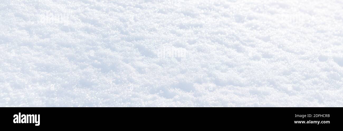 Neve bianca tessitura invernale. Sfondo delle vacanze di Natale. Stagionale fresco bianco colore neve natura sfondo carta da parati. Neve brillante e brillante su sole Foto Stock