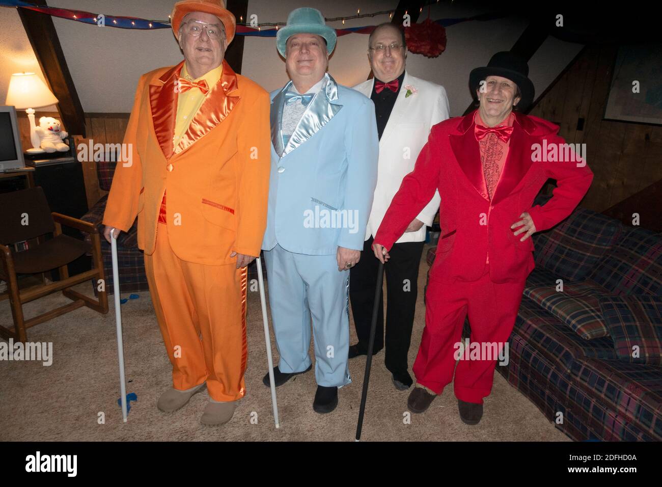 Quattro uomini vestiti con abiti colorati e cappelli di prima qualità per una serata di frivolity in una festa annuale in costume da viaggio. Ironwood Michigan, MICHIGAN, Stati Uniti Foto Stock