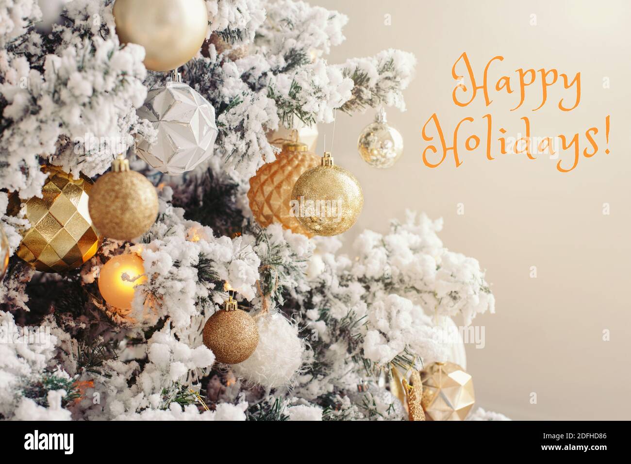 Buone vacanze. Buon Natale. Carta di Natale per il nuovo anno con testo. Albero di Natale decorato per le vacanze invernali. Baubles ornamenti dorati e bianchi Foto Stock