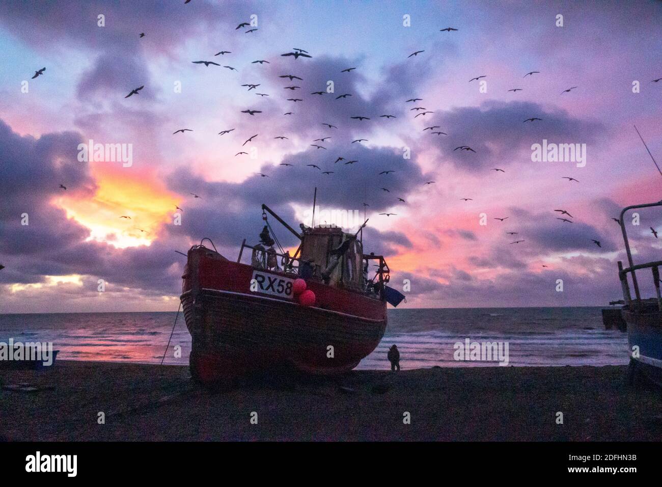 Hastings, East Sussex, Regno Unito. 5 dicembre 2020. I gabbiani girano all'alba sui pescherecci Hastings con un'alba colorata sulla Manica, il giorno dei colloqui di Boris Johnson con il presidente della Commissione europea Ursula von der Leyen, Cercare di sbloccare i diritti di pesca nelle acque britanniche e garantire un accordo commerciale all'ultimo minuto. Carolyn Clarke/Alamy Live News Brexit Foto Stock