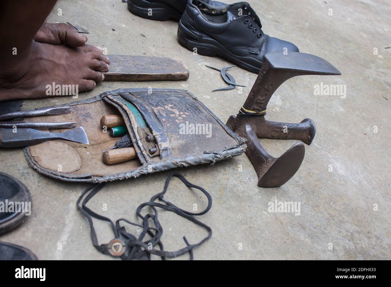 Attrezzi di locale indiano cobbler. Vecchia tasca di cuoio, incudine per riparazione di scarpe, fili, scalpello ecc naturale colpo Foto Stock