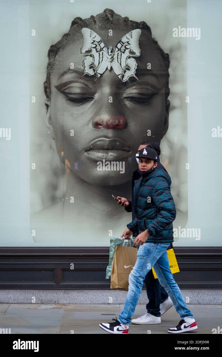 Londra, Regno Unito. 5 dicembre 2020. Gli acquirenti passano davanti a una vetrina accattivante in Regent Street (chiusa al traffico) il primo sabato dopo che le restrizioni di blocco sono state revocate il 2 dicembre. I rivenditori sperano che le vendite fisiche prenderanno nella corsa fino a Natale. Ciò avviene sullo sfondo di due grandi rivenditori Debenhams e Arcadia, proprietario di Topshop, che si sono abbattute nell'amministrazione nell'ultima settimana. Credit: Stephen Chung / Alamy Live News Foto Stock