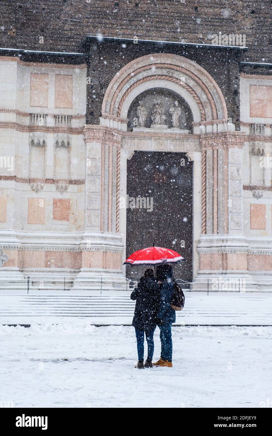 Una coppia sotto un ombrello rosso in caduta di neve di fronte alla Basilica di San Petronio, Piazza maggiore, Bologna, Italia, durante "la bestia da Oriente" Foto Stock