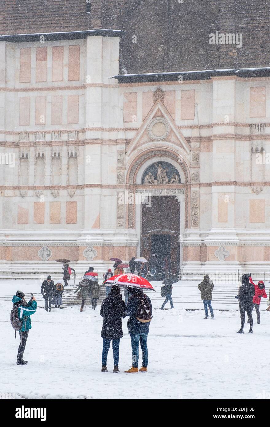 La gente fuori godendo la neve che cade di fronte alla Basilica di San Petronio, Piazza maggiore, Bologna, Italia. Foto Stock