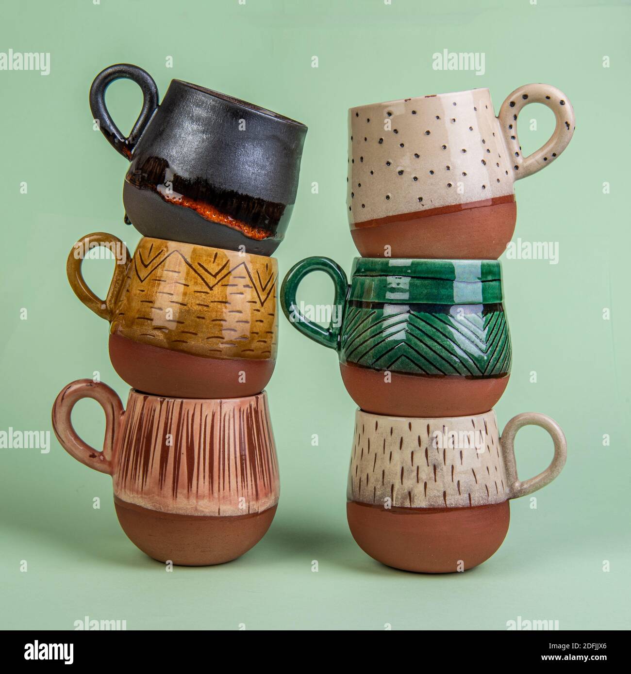 tazze da caffè in ceramica fatte a mano isolate in verde Foto Stock