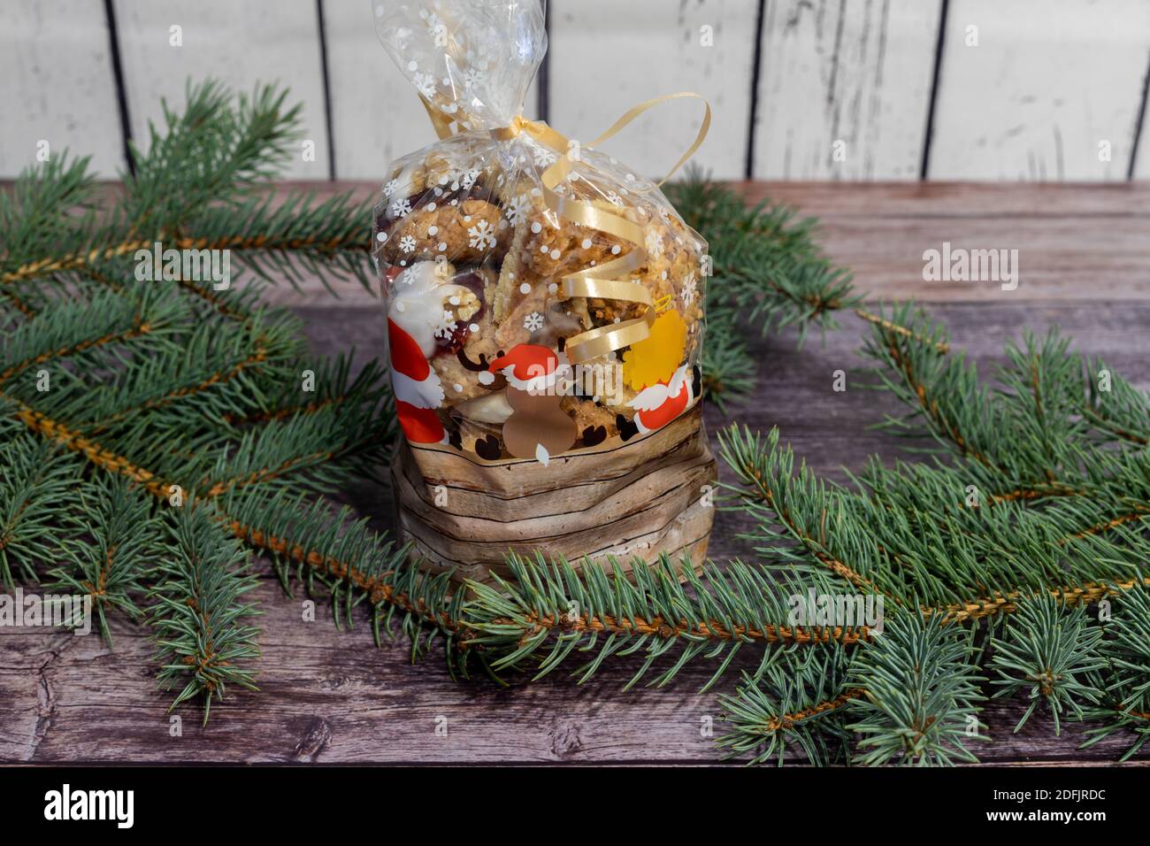 Borsa regalo con biscotti natalizi fatti in casa circondata da rami di abete Foto Stock