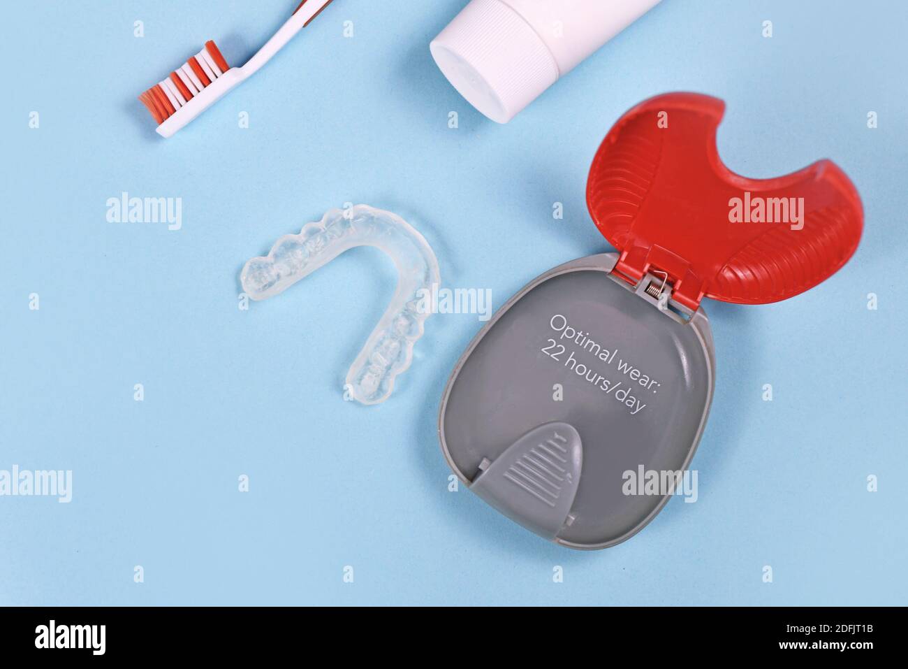 Protezioni per denti personalizzate trasparenti allineatori trasparenti per ganasce inferiori con custodia, spazzola per denti e pasta su sfondo blu Foto Stock