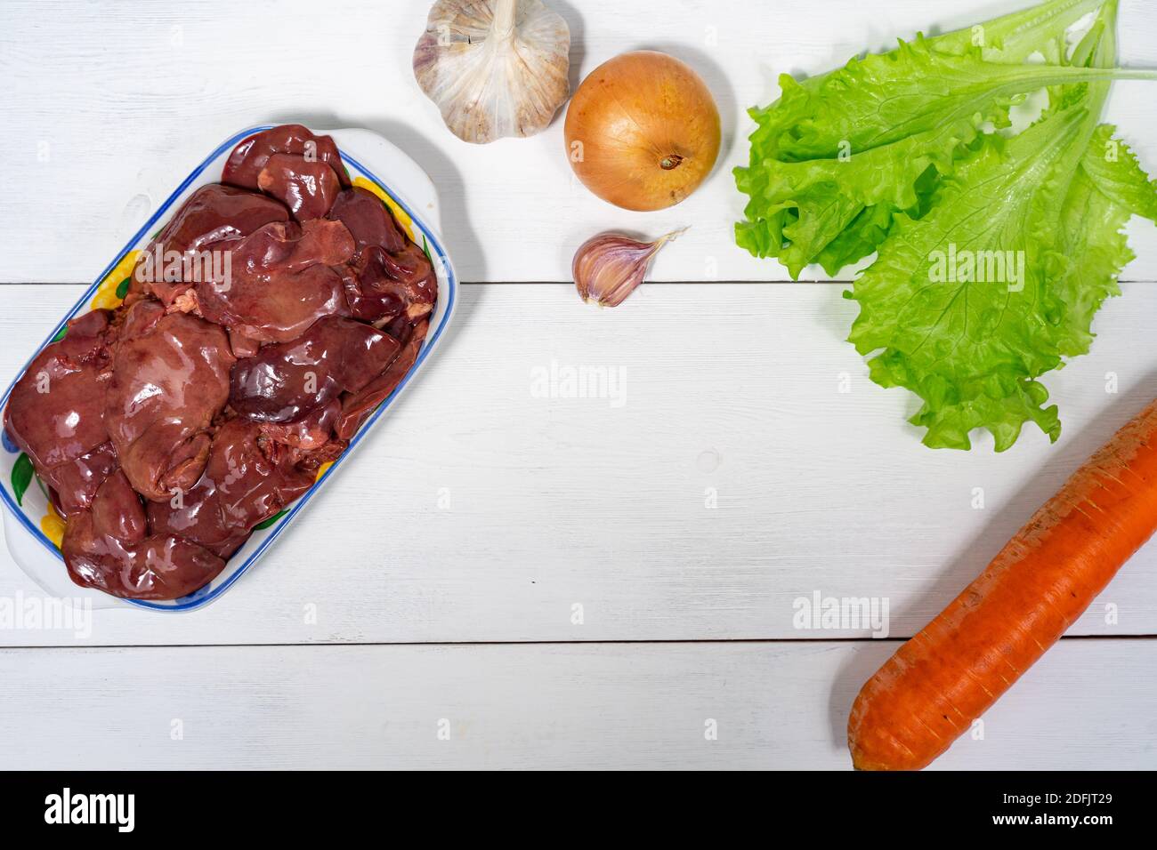 fegato di pollo e verdure su sfondo ligneo. set di cibi crudi per cucinare. spazio per testo e spazio per la copia Foto Stock